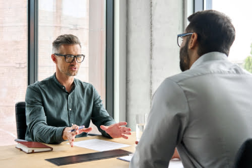 two diverse business executive partners negotiating at board meeting