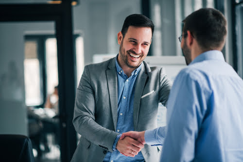 portrait of cheerful young manager handshake with new employee