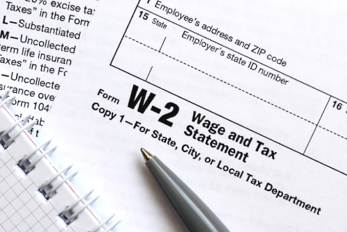 the pen and notebook on the tax form W-2 wage and tax statement