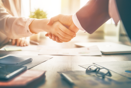 man and woman are shaking hands in office